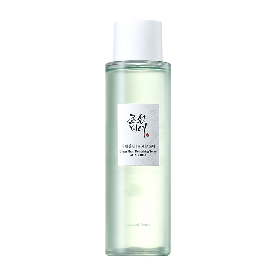 Flaskan med "Green Plum Refreshing Toner" AHA + BHA har en elegant design med en vit kork och genomskinlig kropp som visar den gröna vätskan inuti. Etiketten har en stilren svart och röd text, vilket ger en fräsch och modern känsla.