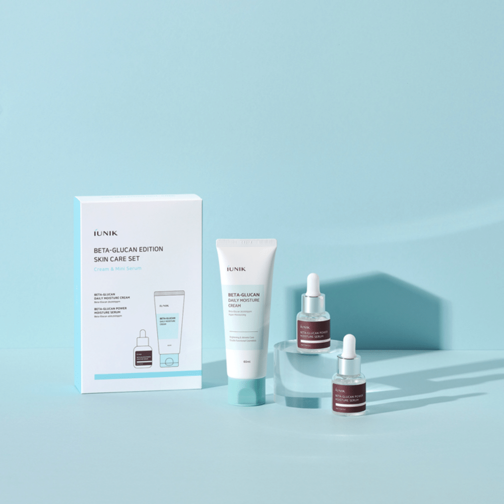 En låda med iUNIK Beta-Glucan Edition Skincare Set inklusive ett fuktserum och daglig fuktkräm på en blå yta.